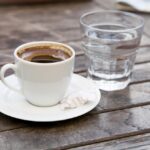Šoljica kafe i čaša vode u kafiću