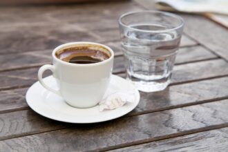 Šoljica kafe i čaša vode u kafiću